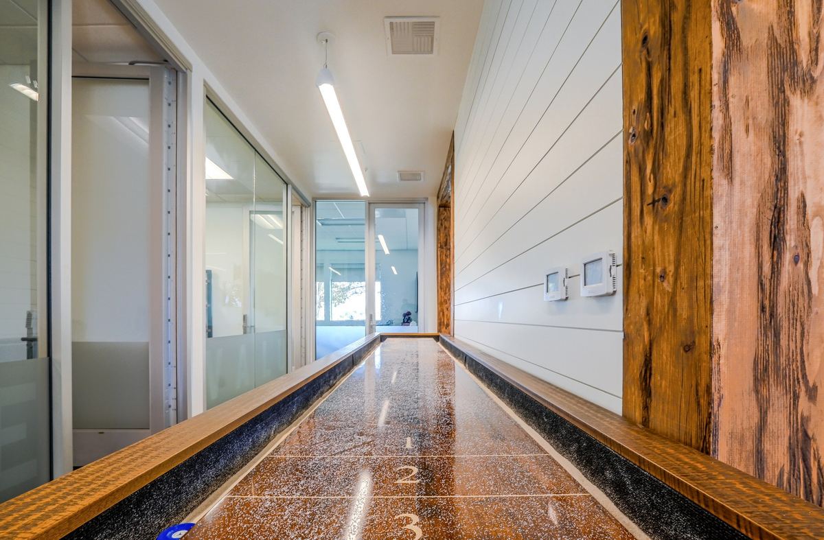 A shuffleboard lane running along a white shiplap wall